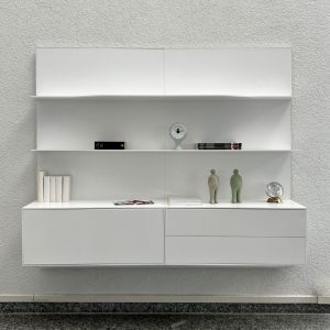 White modern wall-mounted shelving unit with closed cabinets and open shelves, minimal decor on display.