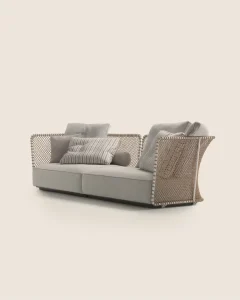Beige woven rattan sectional sofa with light gray cushions and striped throw pillows, shown against a pale background.