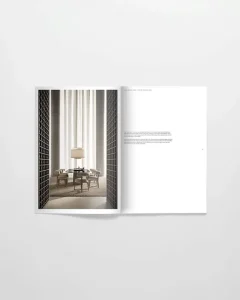 Open magazine spread showing a modern dining area: round table with chairs, a central lamp, flanked by dark lattice walls and tall white drapes.